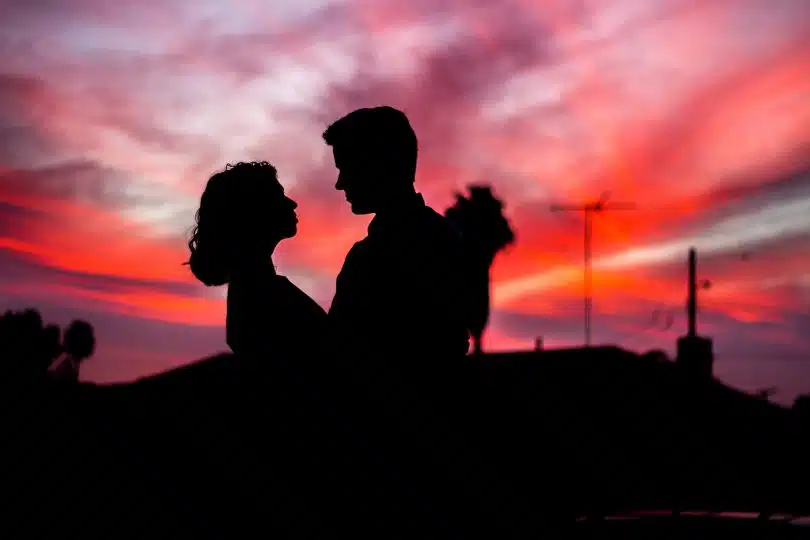 un couple devant le coucher de soleil