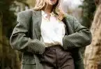 woman in gray and white polka dot blazer standing and smiling