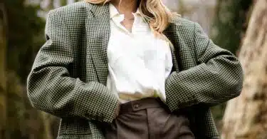 woman in gray and white polka dot blazer standing and smiling