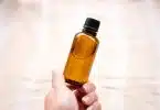 a person holding a bottle of essential oils