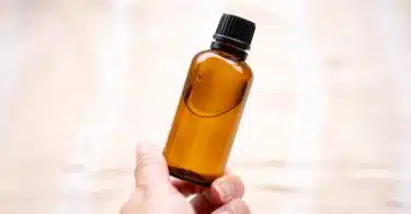 a person holding a bottle of essential oils