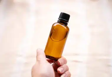 a person holding a bottle of essential oils