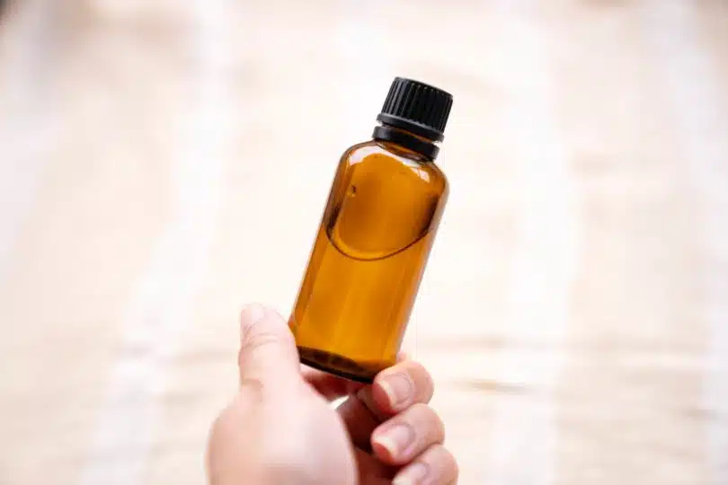 a person holding a bottle of essential oils