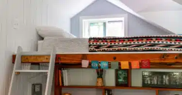 a loft bed with a ladder and bookshelf